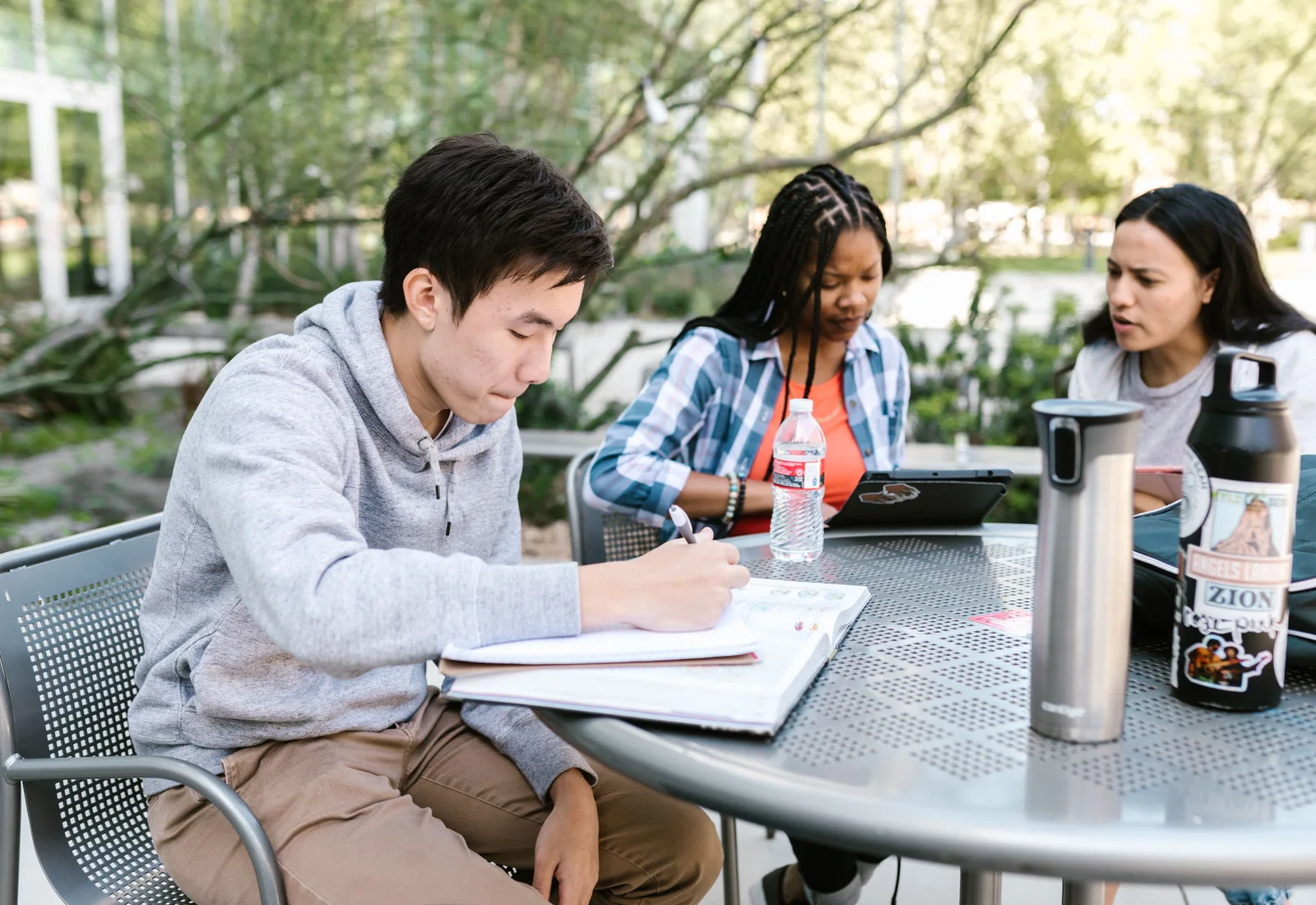 University students working together with notebooks and digital devices